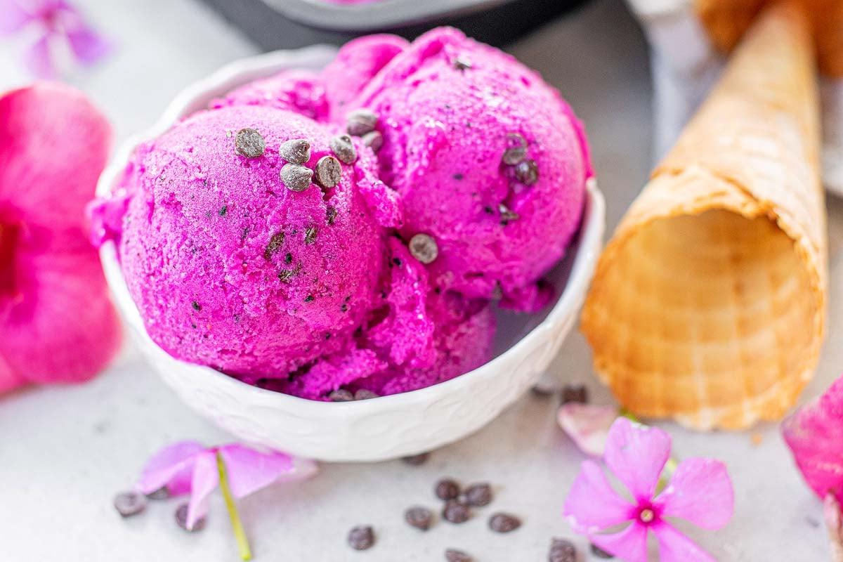 Παγωτό dragon fruit σε μπολ με λουλούδια.