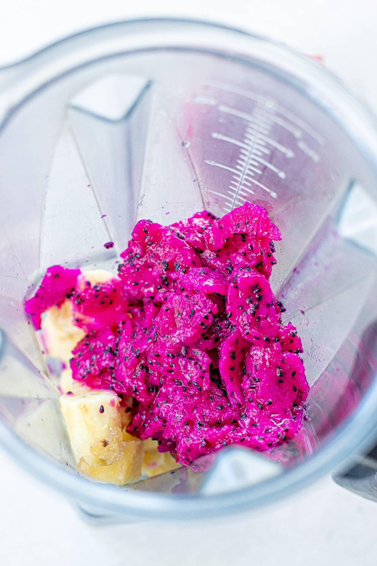 Κομμάτια φωτεινού ροζ dragon fruit και μπανάνας σε ένα μπλέντερ, έτοιμα να αναμειχθούν για ένα ζωντανό παγωτό Dragon Fruit ή ένα πολύχρωμο παγωτό.