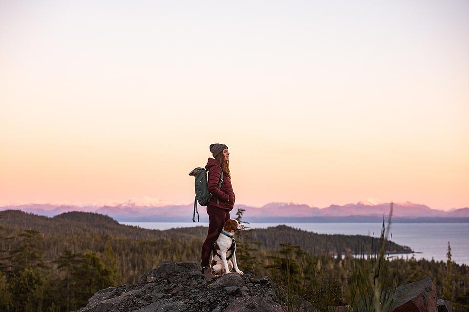 Woman hiking with a dog.