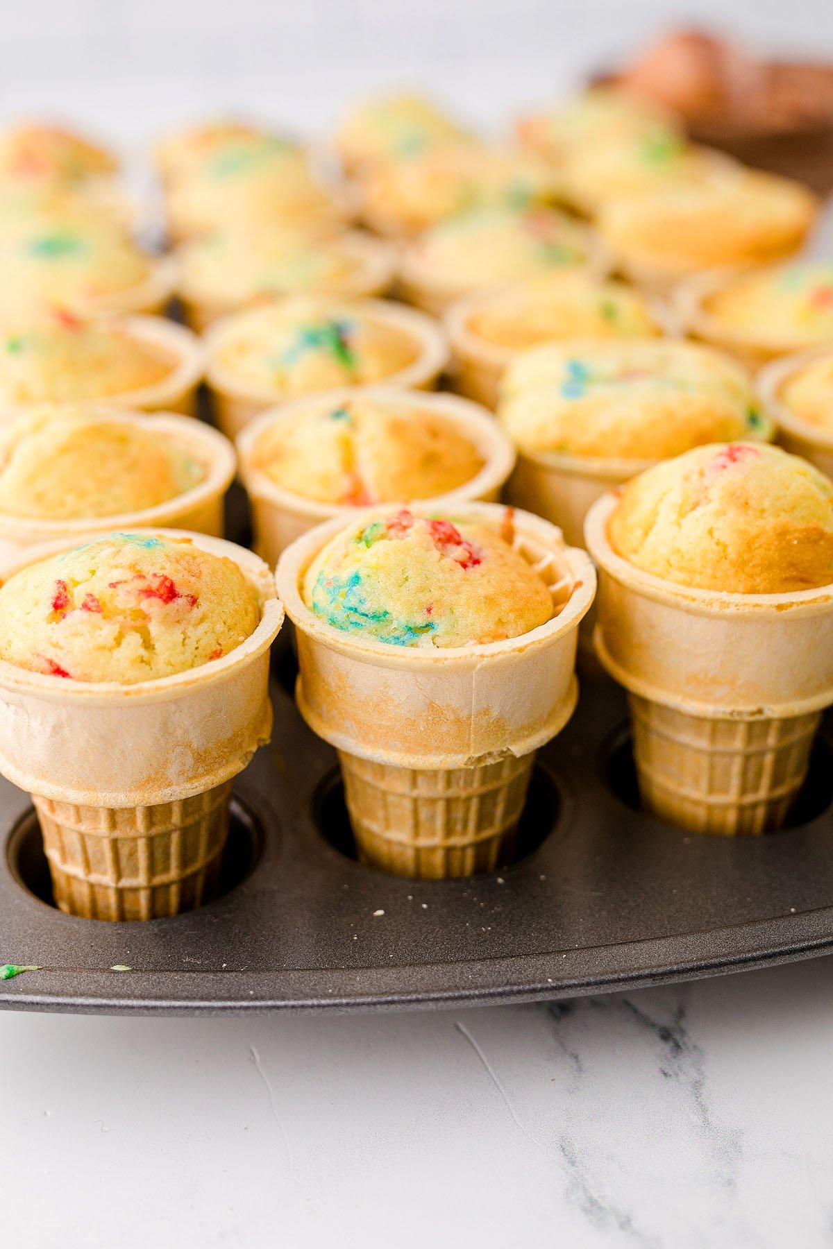 Cupcakes σε χωνάκι παγωτού με funfetti ψημένο σε σπιτικά χωνάκια κέικ, τοποθετημένα σε μια φόρμα για muffins σε έναν μαρμάρινο πάγκο – τέλεια cupcakes για πάρτι γενεθλίων!