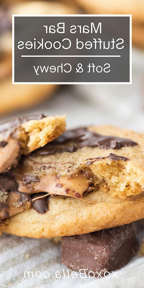 Κοντινό πλάνο ενός Mars Bar stuffed cookie, ανοιγμένο για να δείξει λιωμένη σοκολάτα και καραμέλα στο εσωτερικό – μια δελεαστική ματιά σε αυτή την ακαταμάχητη συνταγή γεμιστού μπισκότου.