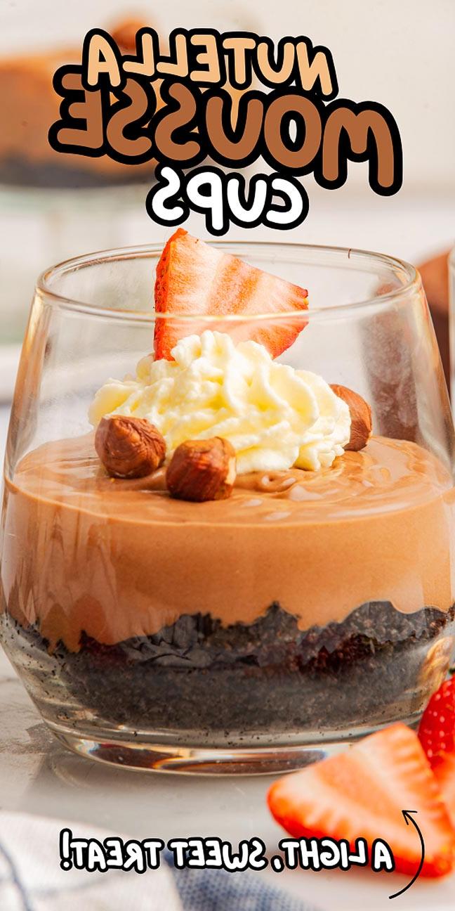 Γυάλινο ποτήρι γεμάτο με μους Nutella, με σαντιγί, ζουμερές φράουλες και τραγανά φουντούκια πάνω σε βάση από ψίχουλα μπισκότων. Κείμενο: "Ποτηράκια Μους Nutella" και "Ένα ελαφρύ, γλυκό κέρασμα!".