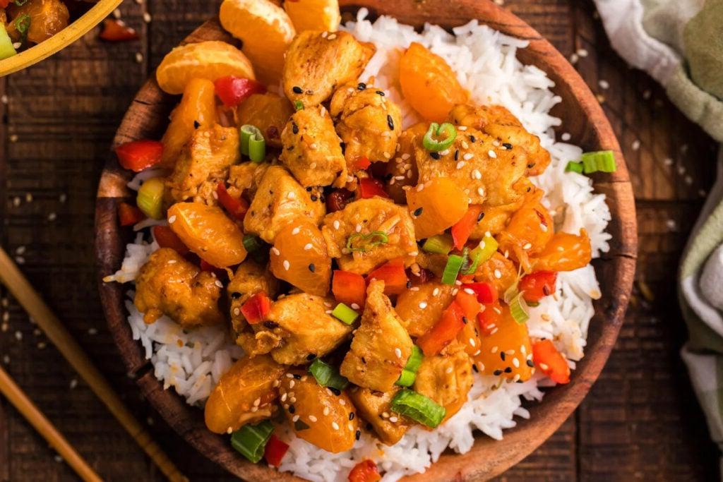 Κοτόπουλο stir fry με μανταρίνι σε μπολ με ρύζι.