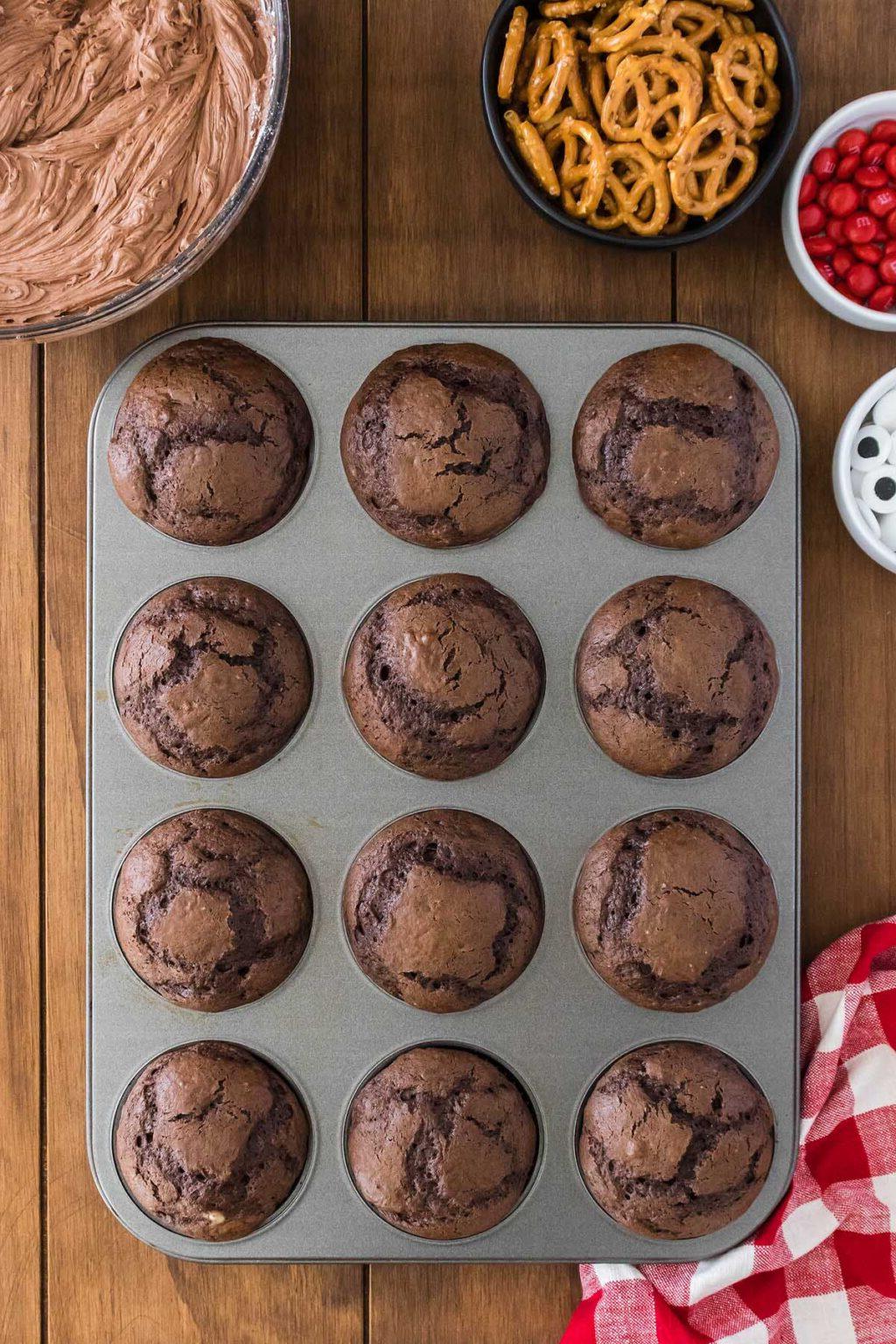 Σοκολατένια cupcakes σε φόρμα για muffins με μπαστούνια πρέτσελ, διακοσμημένα σαν τάρανδος.