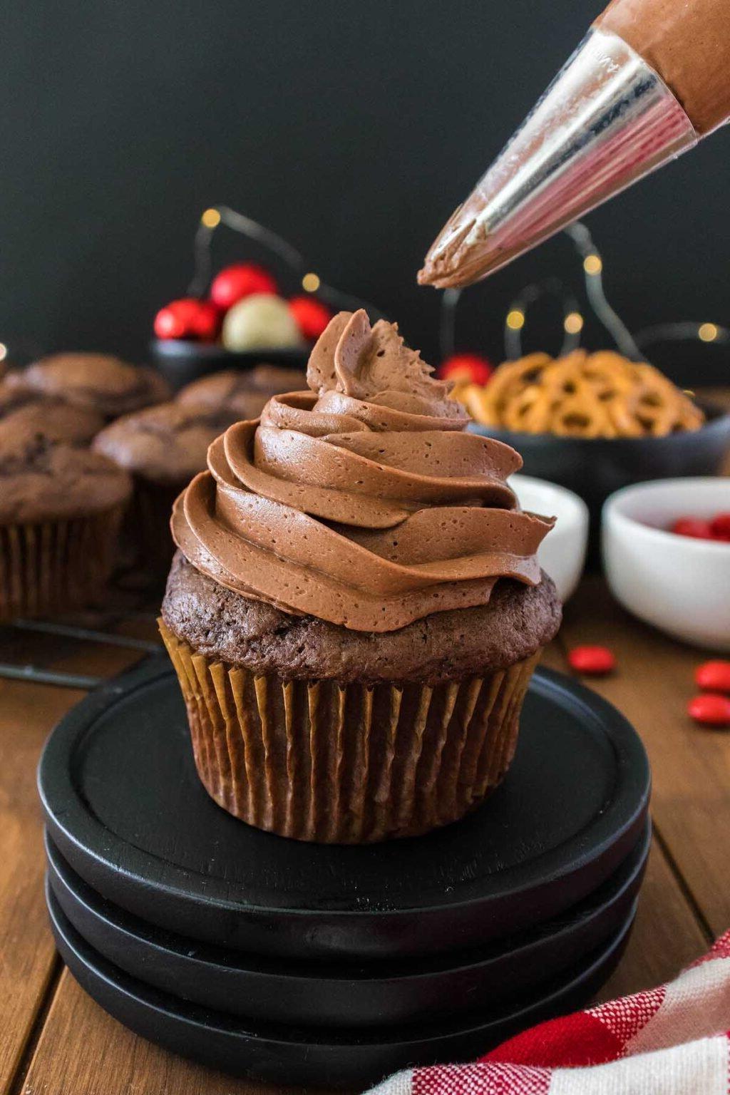 Ένα χριστουγεννιάτικο cupcake γλασάρεται με γλάσο σοκολάτας.