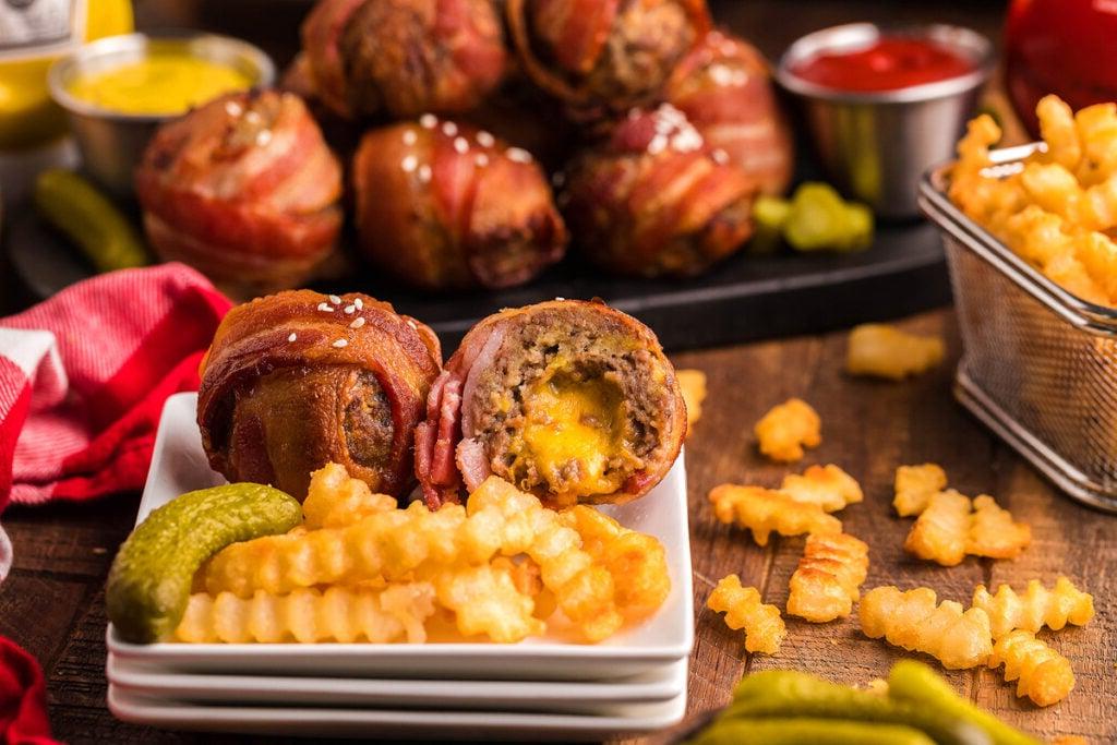 Ένα πιάτο με μπουκιές cheeseburger τυλιγμένες σε μπέικον και μερικές πατάτες τηγανητές.