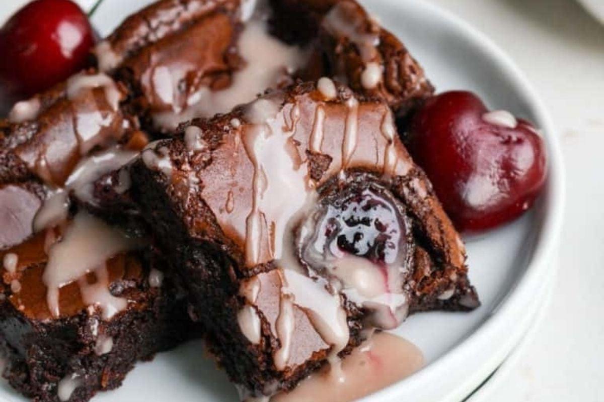 Brownies σοκολάτας με κεράσια και επικάλυψη σοκολάτας σε ένα πιάτο.