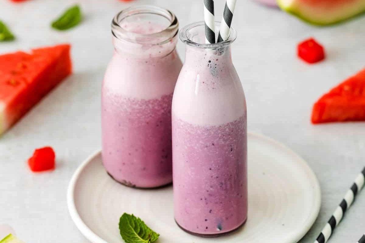 Δύο μπουκάλια smoothie καρπουζιού σε πιάτο, συνοδευόμενα από συνταγές pinwheel.