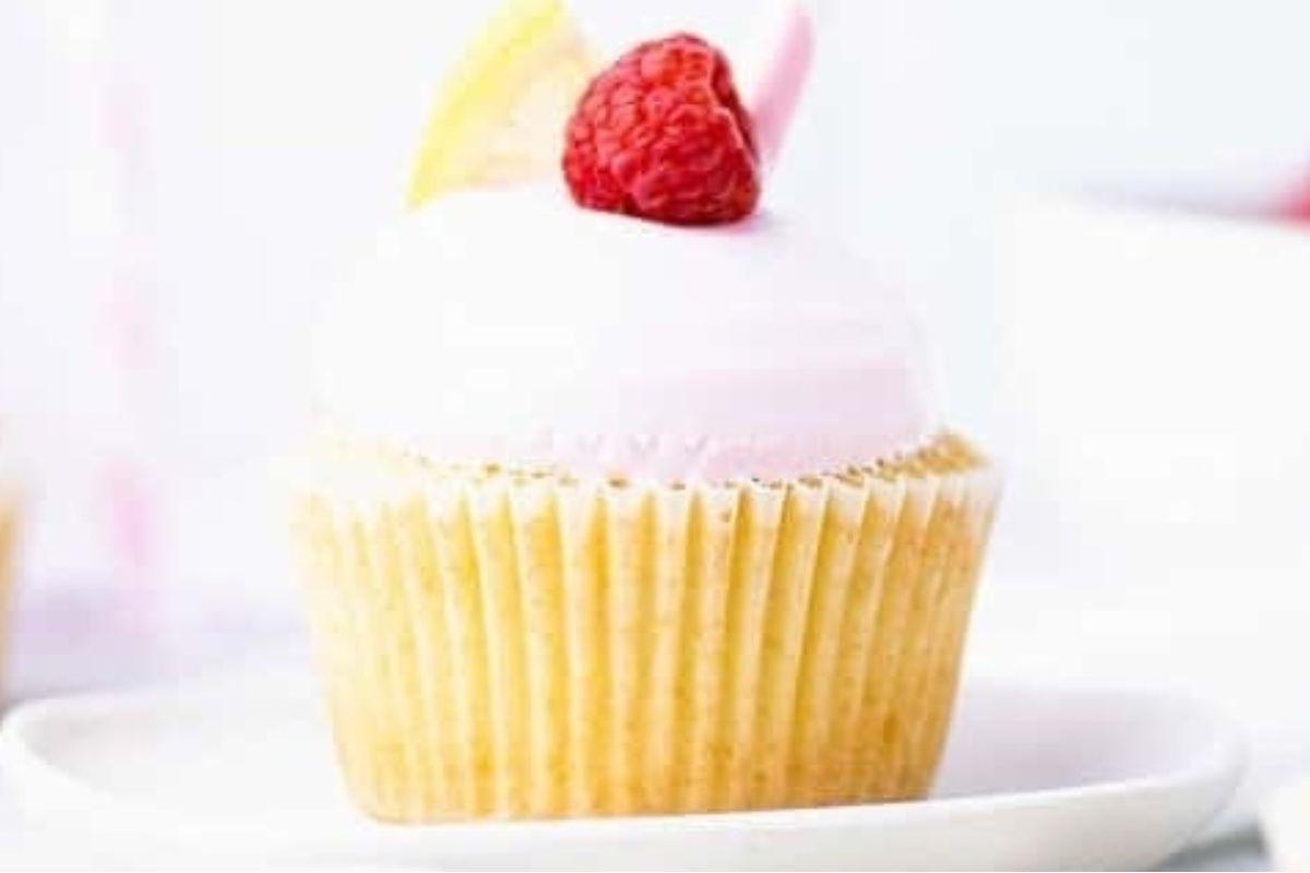 Ένα ροζ cupcake με βατόμουρο στην κορυφή.
