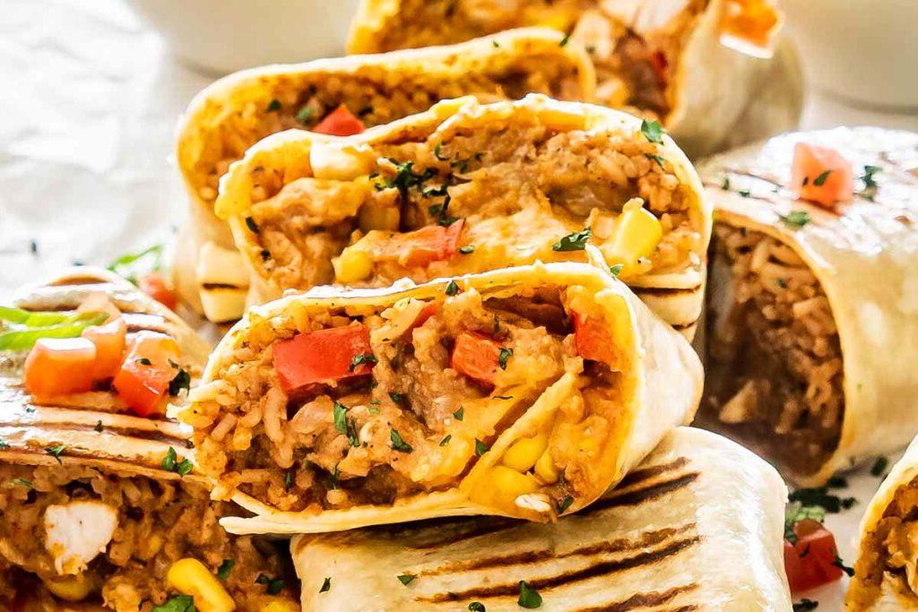 Μια πιατέλα με κοτόπουλο burritos κομμένα στη μέση.