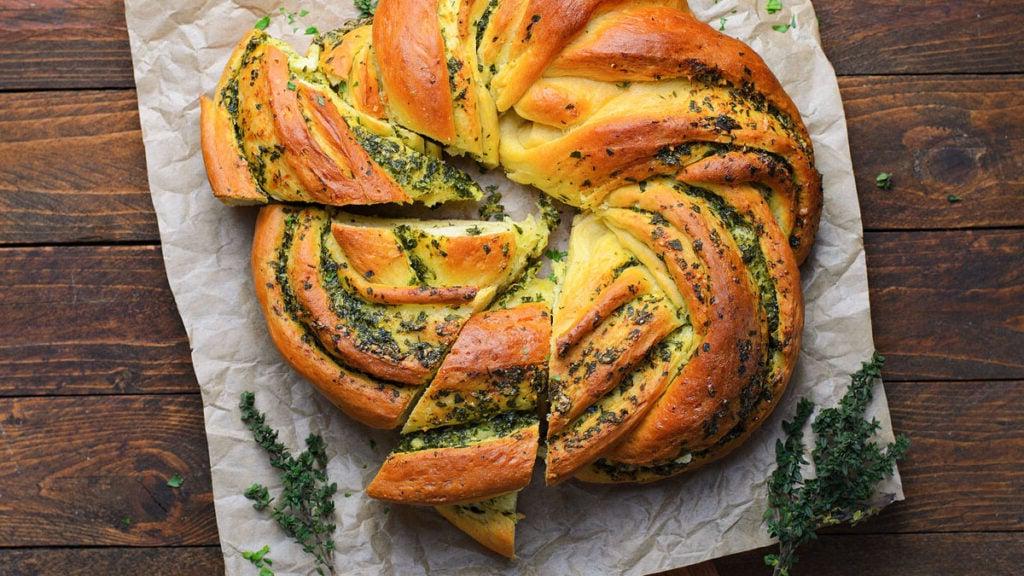Food blogger, Bella Bucchiotti της xoxoBella, μοιράζεται μια συνταγή για ένα στεφάνι ψωμιού με σκόρδο και βότανα. Προσθέστε αυτό το σπιτικό ψωμί στο μενού του γιορτινού σας δείπνου!