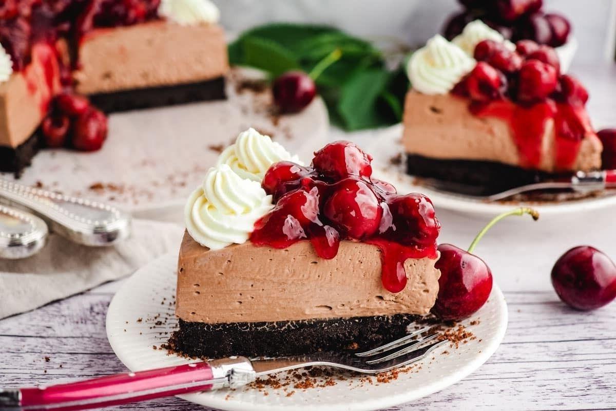 Μια λαχταριστή φέτα cheesecake σοκολάτας με κεράσι σε ένα πιάτο.