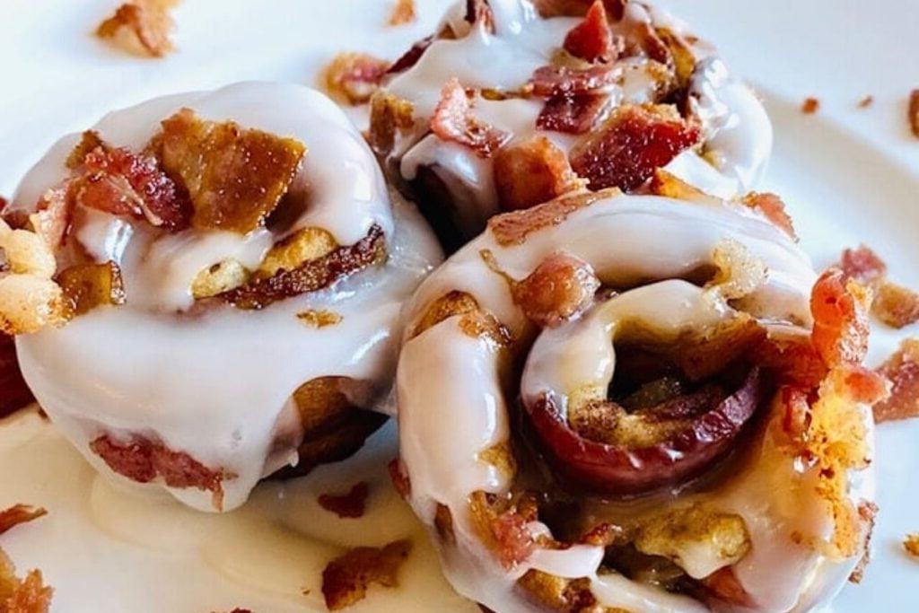 Three bacon cinnamon rolls on a plate.