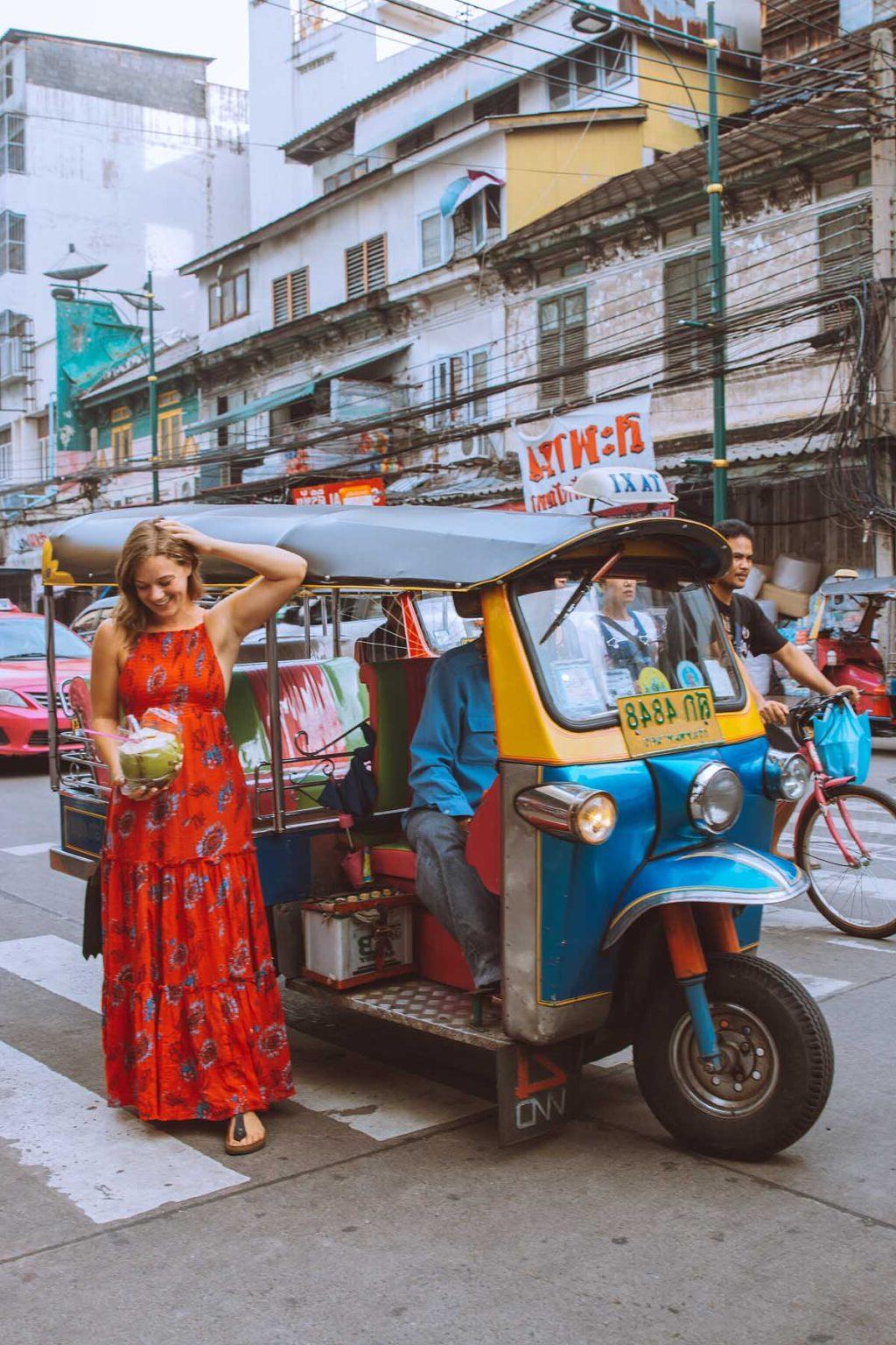 Woman beside a TukTik in Thailand.