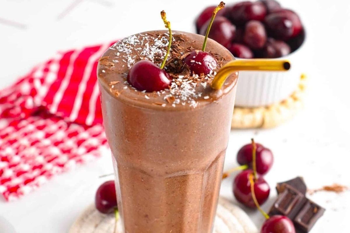 Ένα νόστιμο και δροσιστικό smoothie σοκολάτας με την απολαυστική προσθήκη κερασιών, ιδανικό για απόλαυση με καλαμάκι.