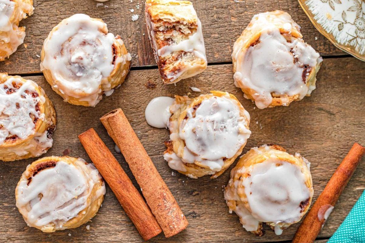 Κανελοψωμάκια Pillsbury με γλάσο και ξυλάκια κανέλας σε ξύλινο τραπέζι.