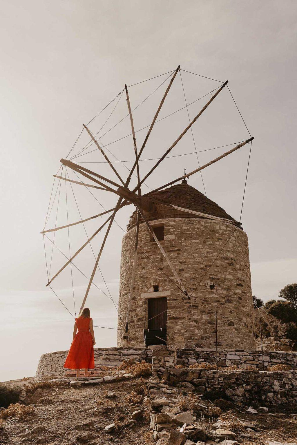 Woman by a windmill in Greece.