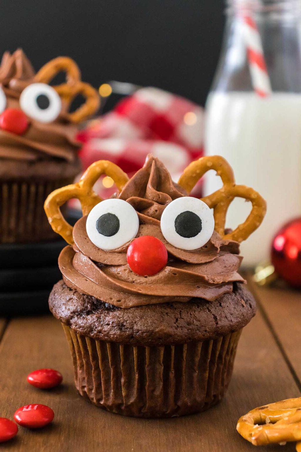Cupcakes ταράνδου με σοκολατένιες διακοσμήσεις σε ξύλινο τραπέζι.