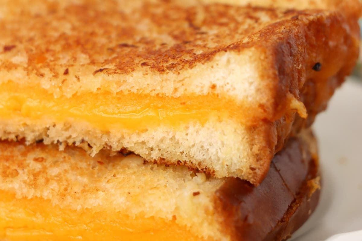 Κοντινό πλάνο συνταγών για grilled cheese με λιωμένο τυρί και αρώματα σκόρδου.