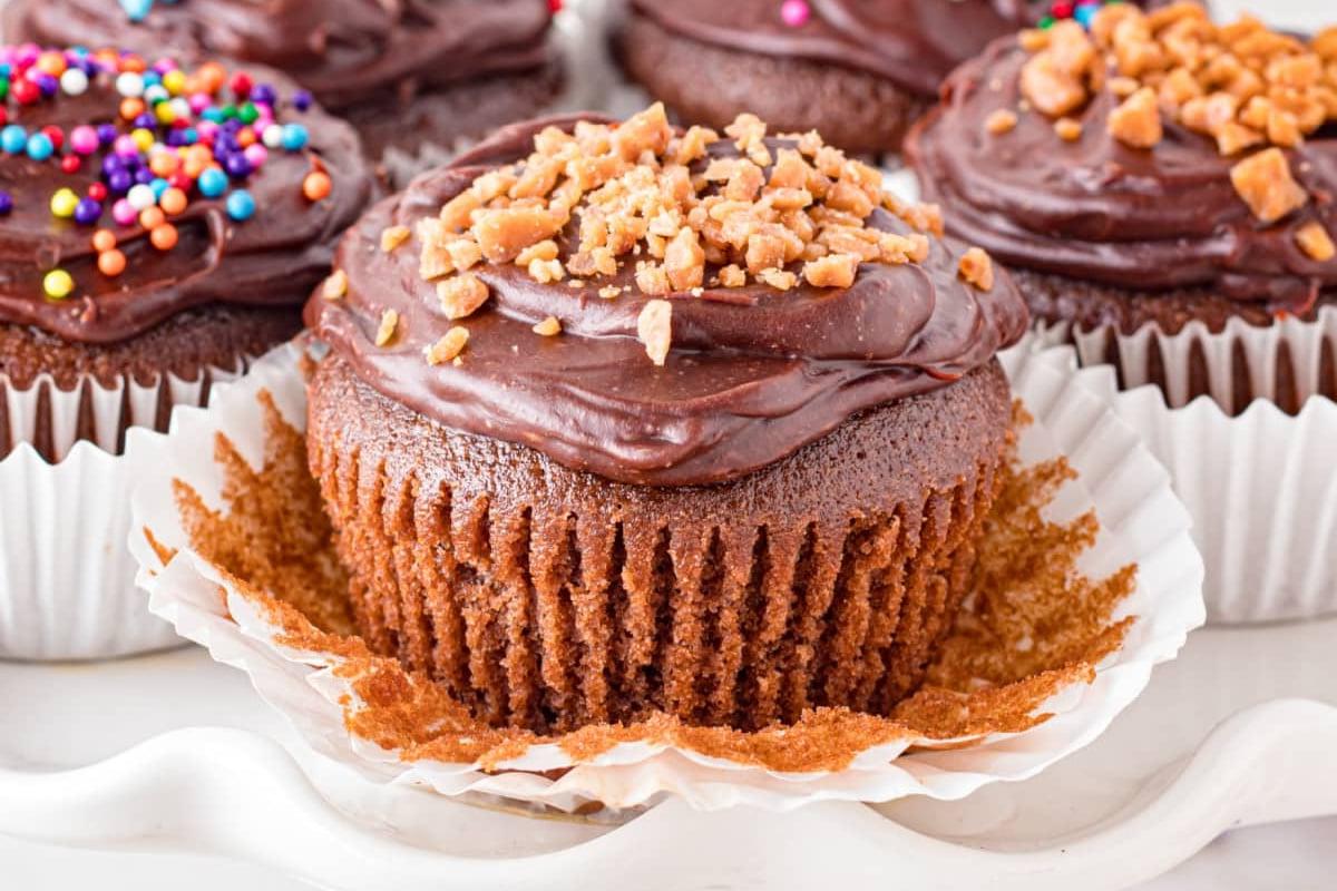 Σοκολατένια cupcakes με διάφορες επικαλύψεις σε λευκή επιφάνεια.