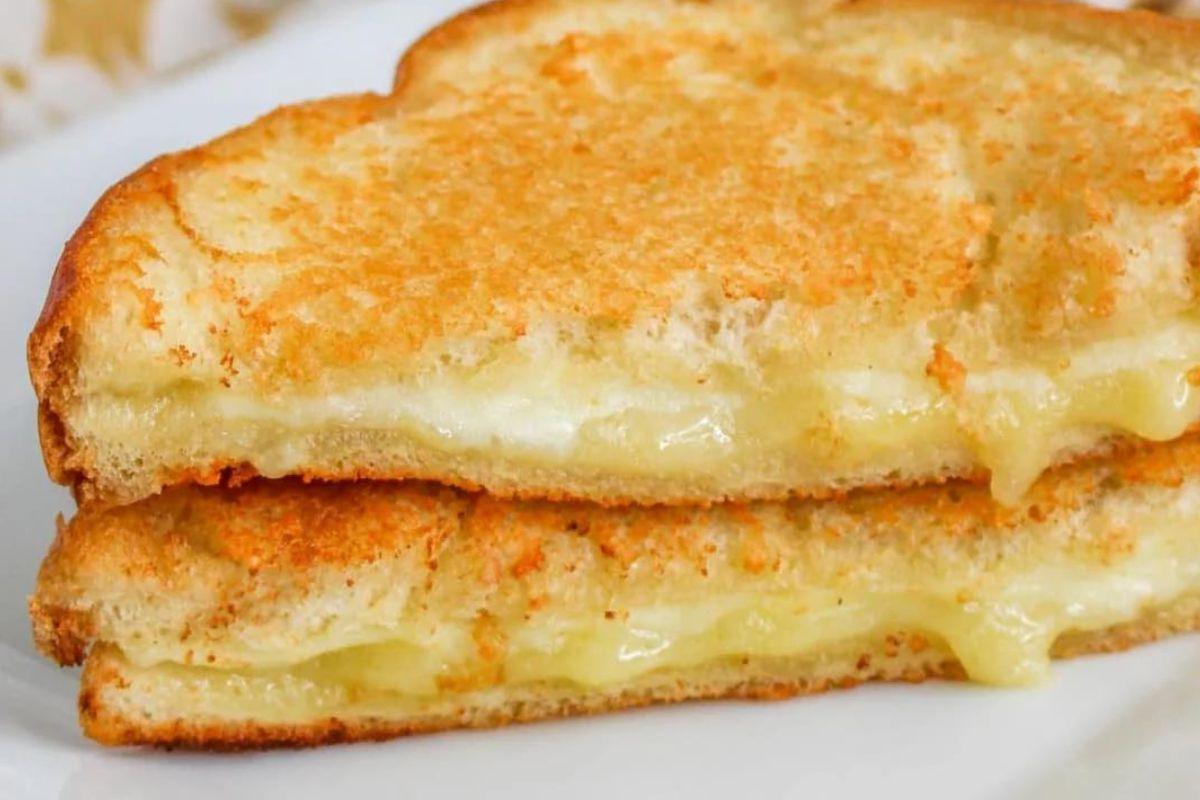 Ένα σάντουιτς grilled cheese με λιωμένο τυρί που ξεχειλίζει, τέλειο για να δοκιμάσετε διαφορετικές συνταγές grilled cheese.