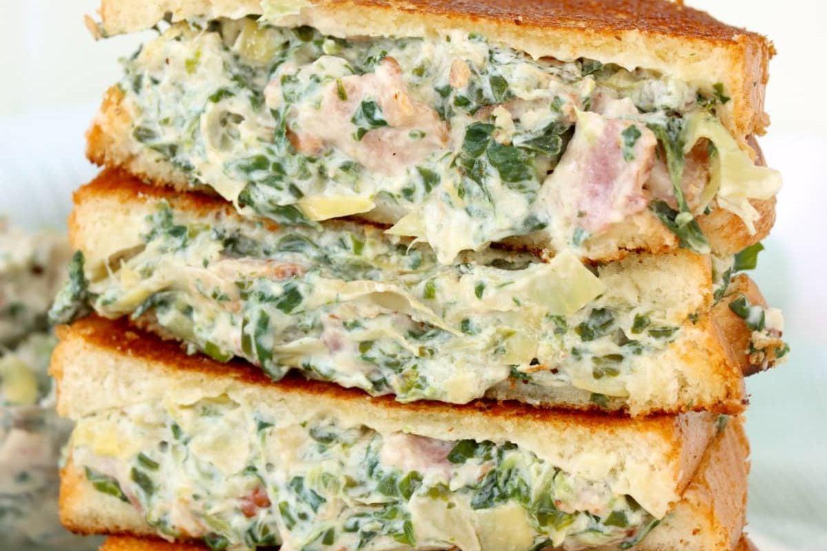 Κοντινό πλάνο ενός σάντουιτς grilled cheese με σπανάκι και αγκινάρα από τη συλλογή συνταγών grilled cheese.