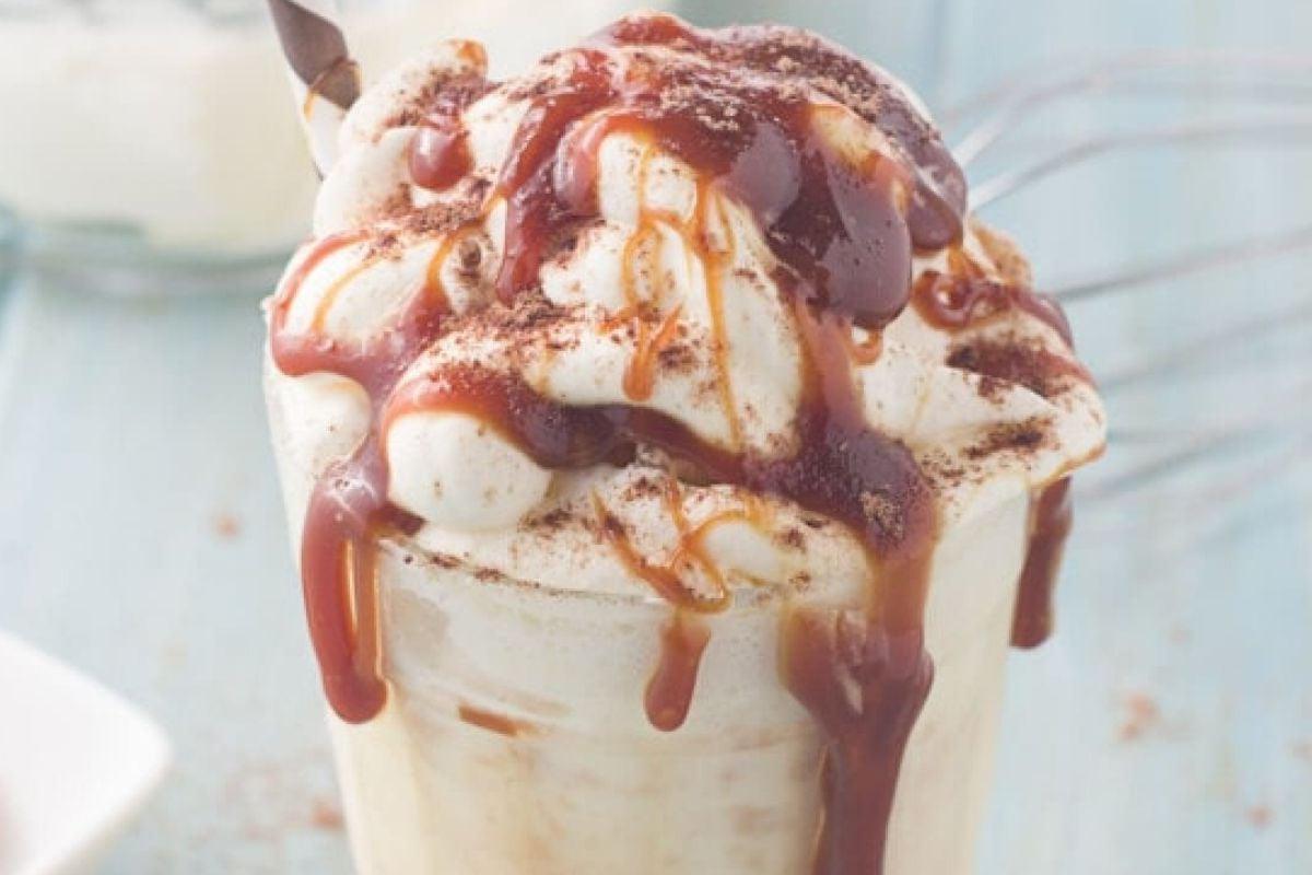 Ένα milkshake με σαντιγί, σιρόπι καραμέλας από Συνταγές Καραμέλας και πασπαλισμένο με σκόνη κακάο.