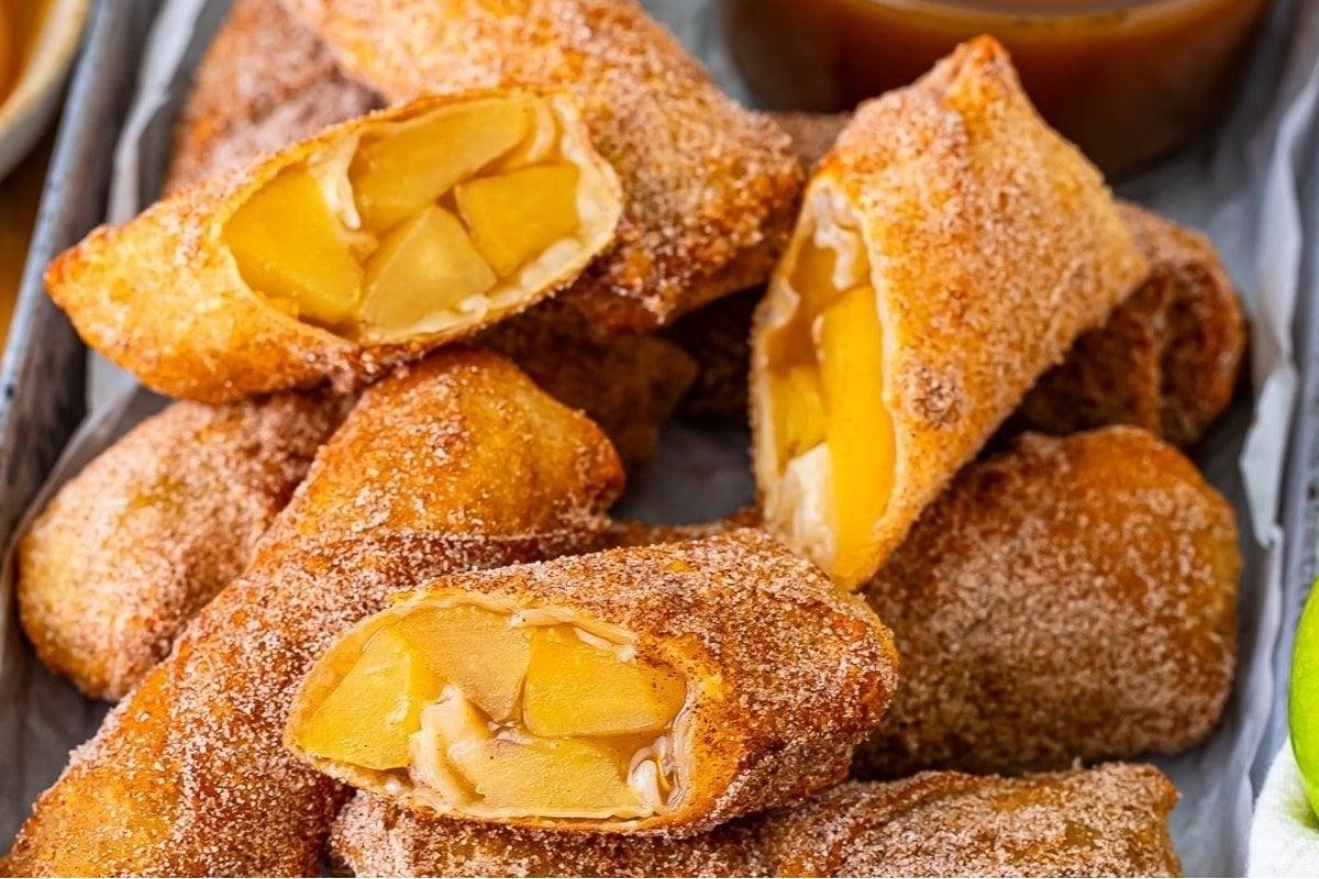 Μια στοίβα από eggrolls με ένα φλιτζάνι σάλτσα.