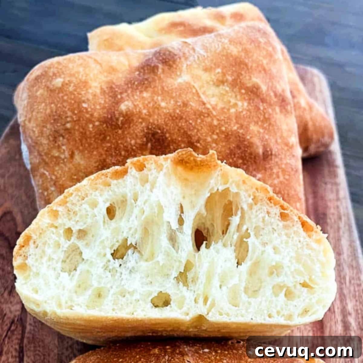 Εύκολα Ψωμάκια Τσιαπάτα 2 ciabatta rolls on a plate and sliced in half.