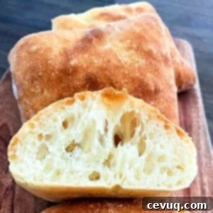 Εύκολα Ψωμάκια Τσιαπάτα 12 ciabatta rolls on a plate and sliced in half.