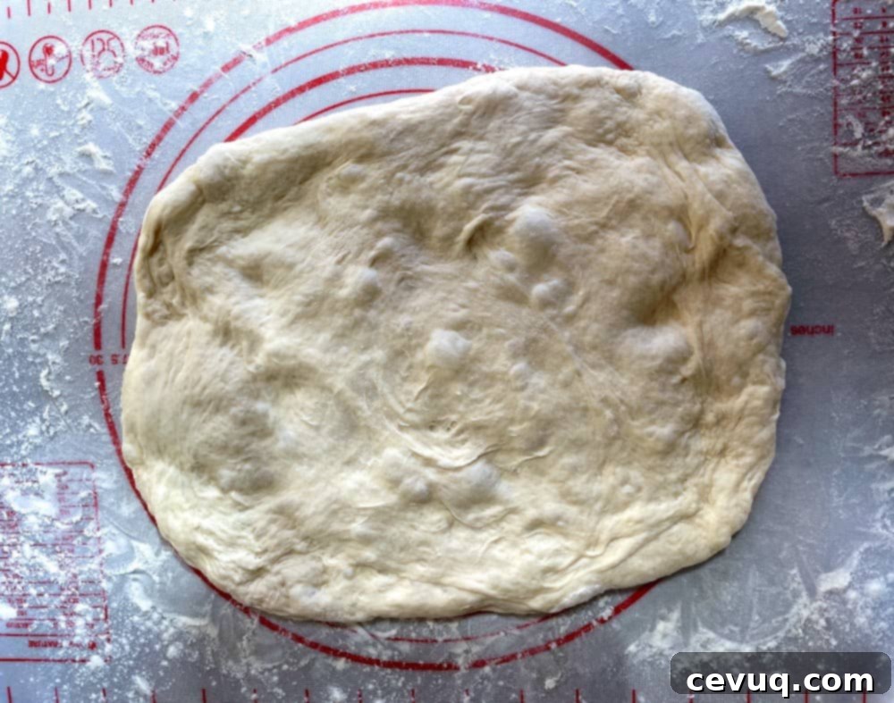 Εύκολα Ψωμάκια Τσιαπάτα 8 ciabatta dough pressed out into a rectangle.