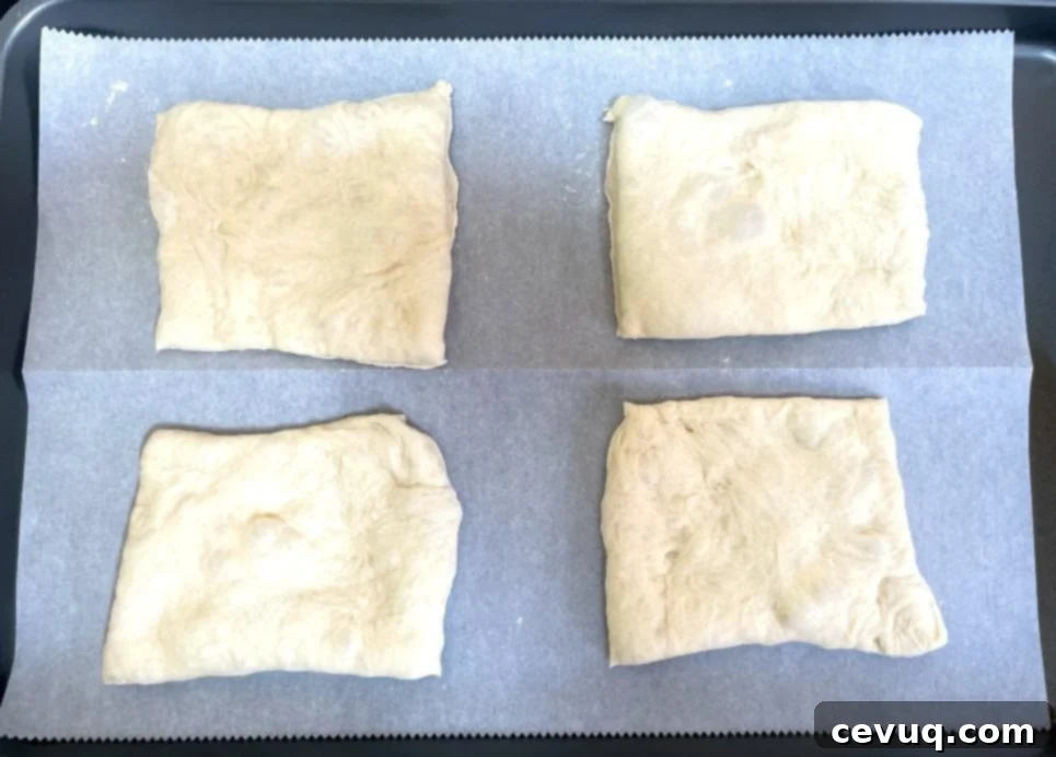 Εύκολα Ψωμάκια Τσιαπάτα 9 ciabatta dough cut into rectangles and placed on parchment paper.