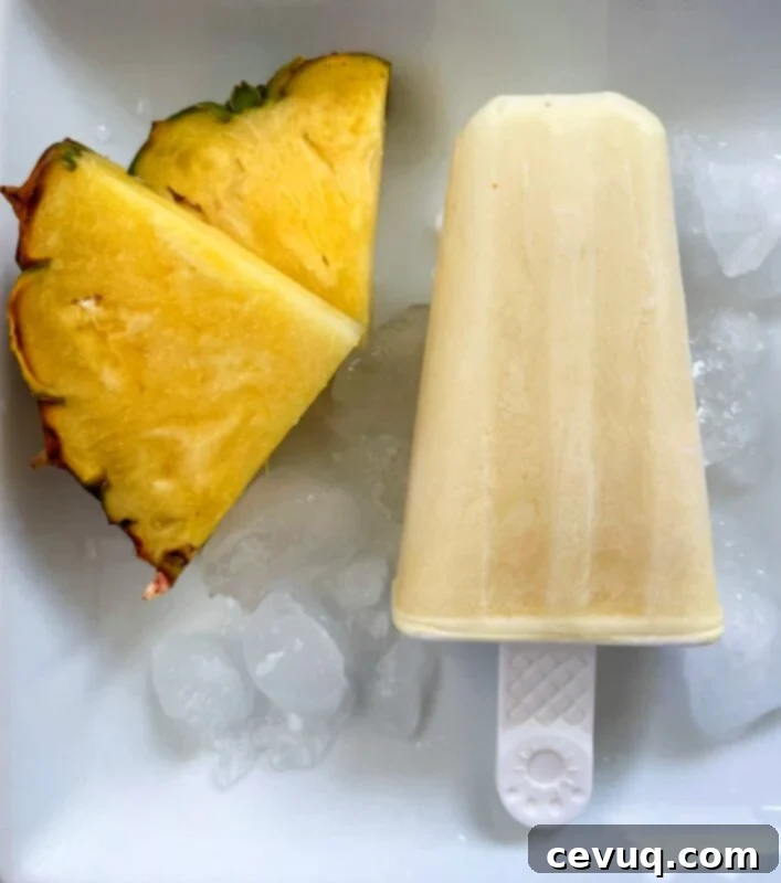 Δροσερό Ξυλάκι Ανανά 3 creamy pineapple popsicle next to fresh pineapple slices