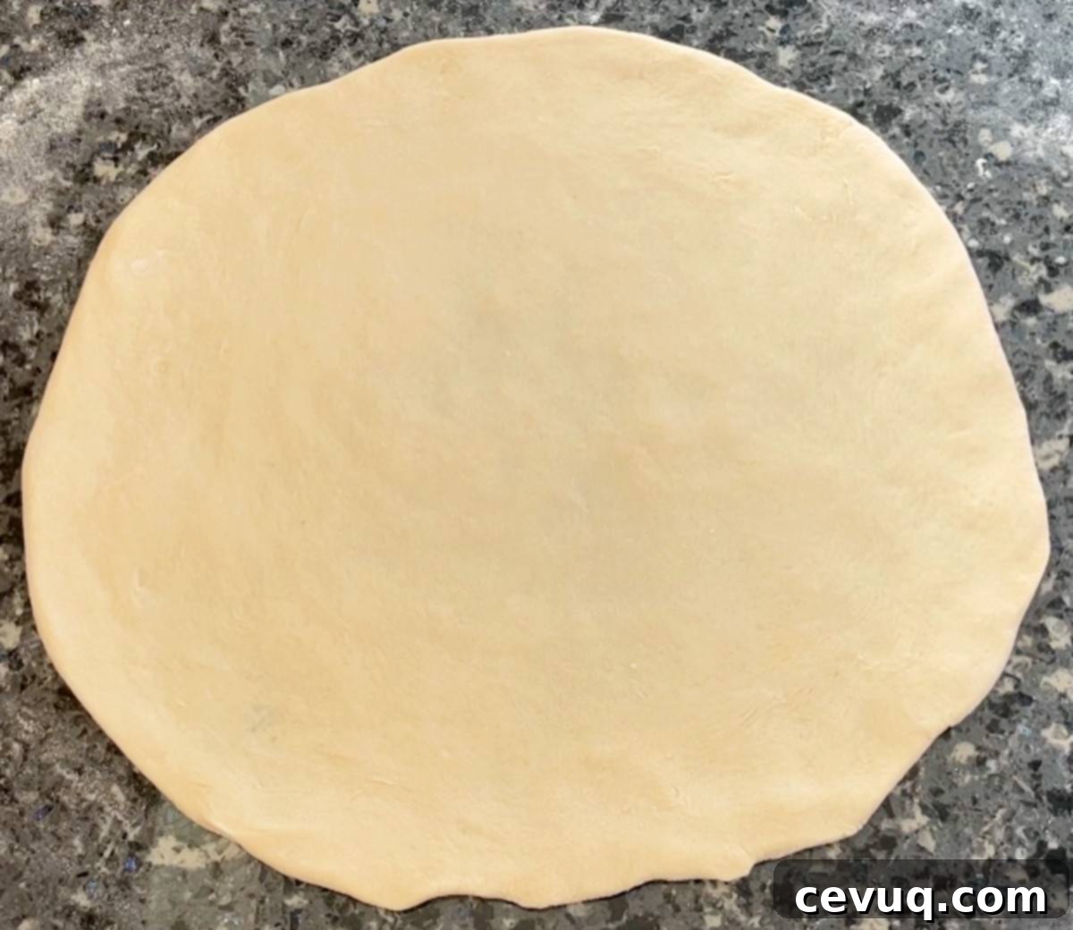 Συνταγή ζύμης πίτσας χωρίς ζύμωμα 9 easy homemade pizza dough rolled out on a counter.