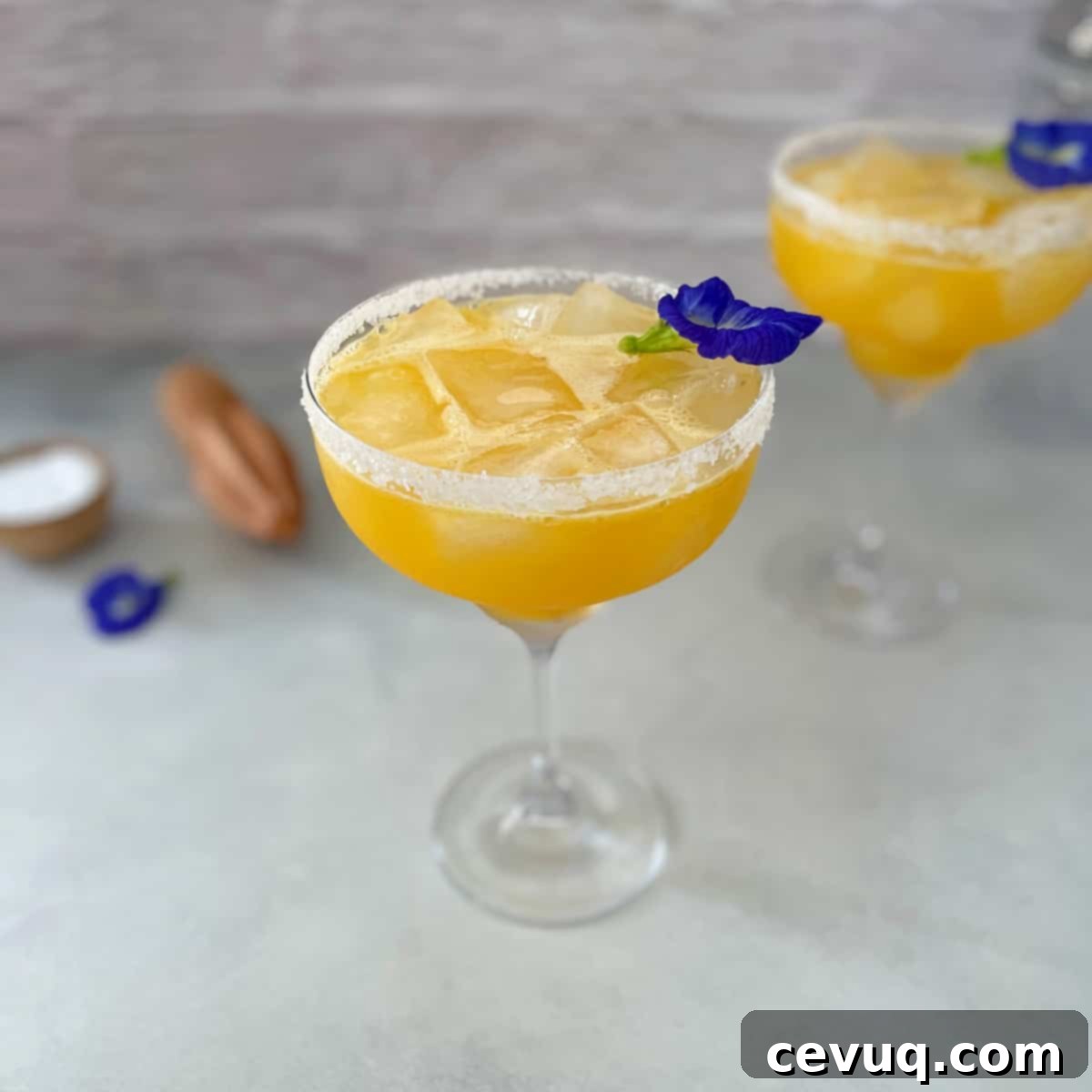 Πασιφλόρα Μαργαρίτα 2 passion fruit margarita on the rocks with edible flower garnish.