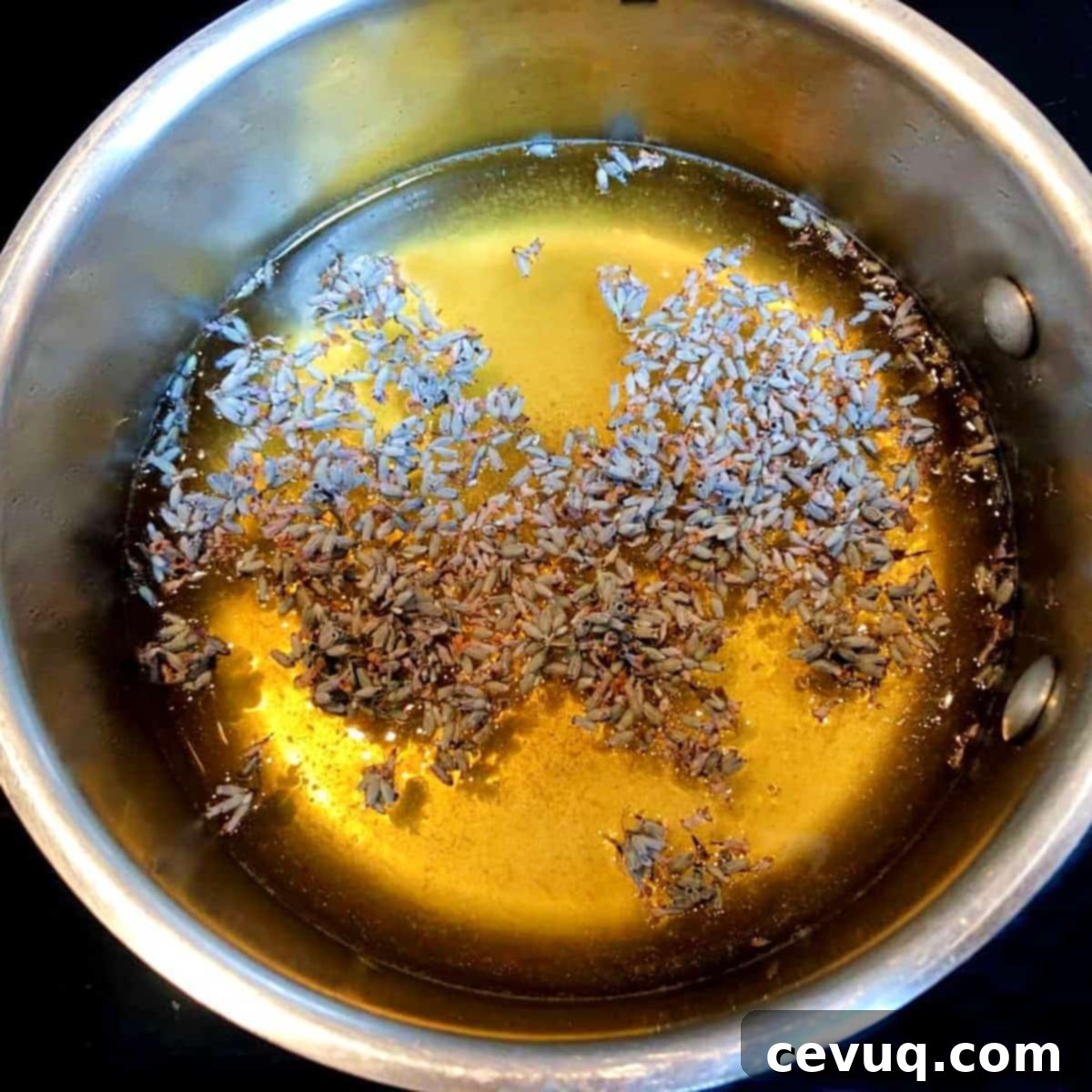 Δημιουργώντας Σιρόπι Μέλι-Λεβάντα 5 lavender, water, and honey in a saucepan.