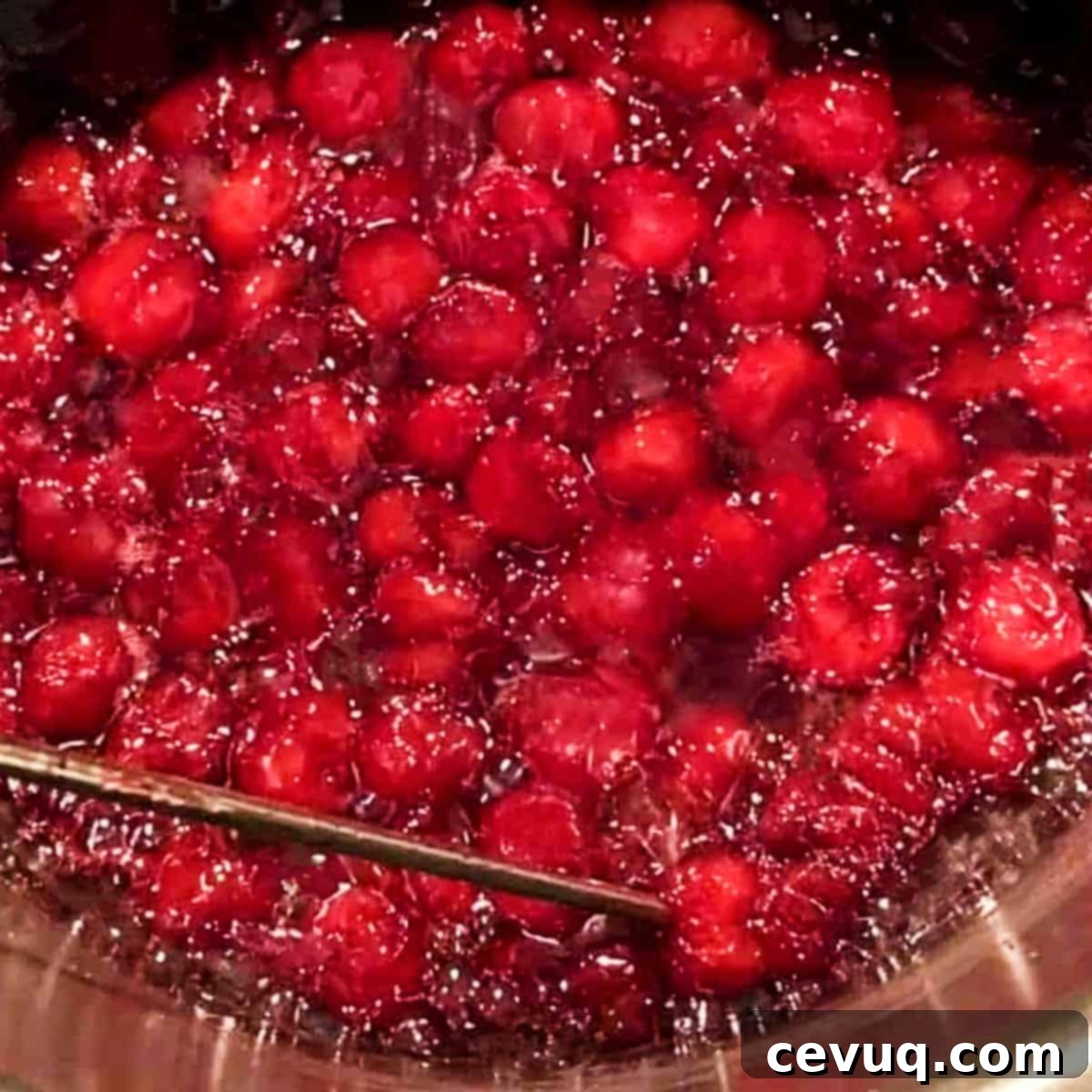 Συνταγή Βύσσινου Αμαρένα 4 amarena cherries cooking in a pan with a candy thermometer.