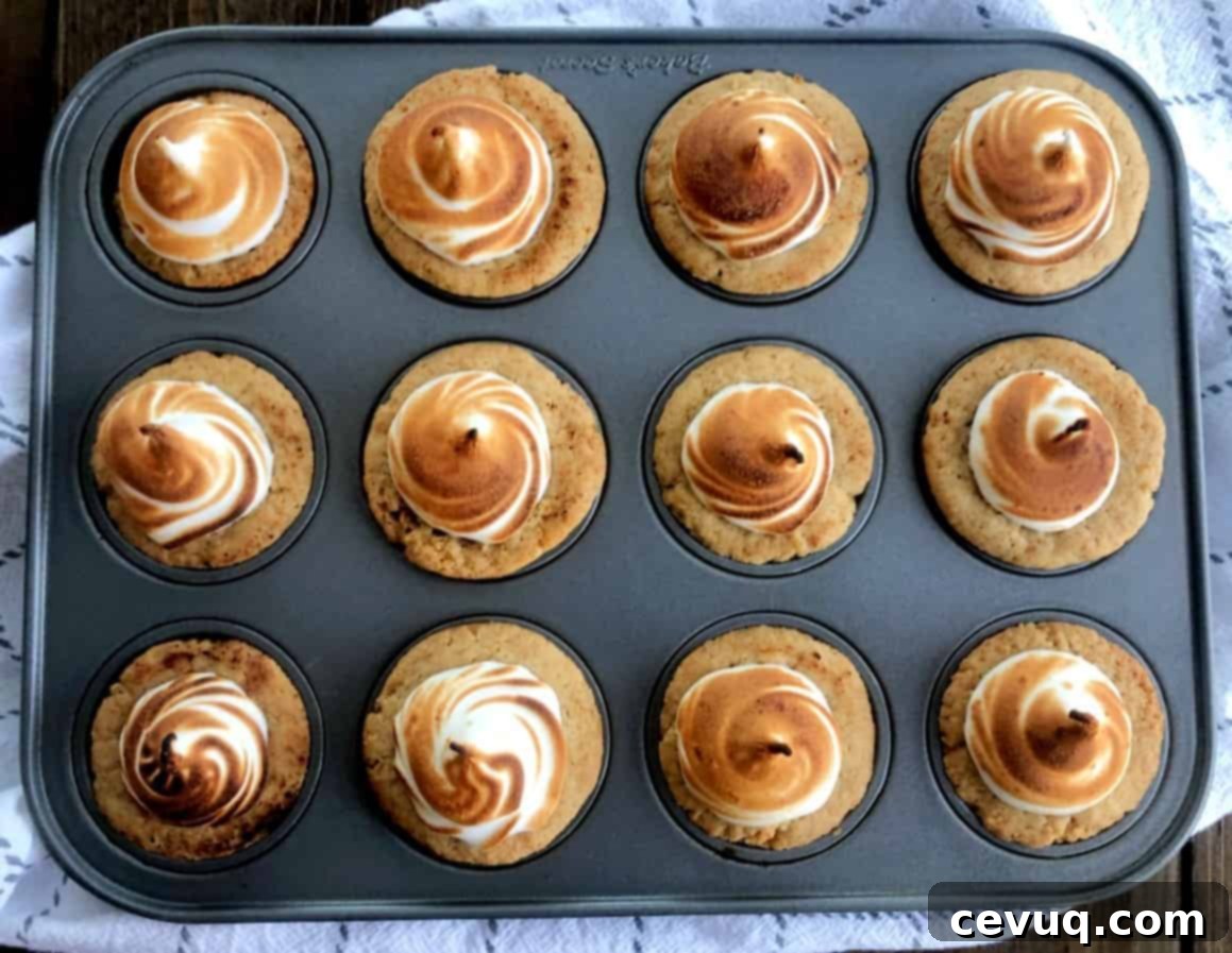 Φωλιές Μαρέγκας με Ζαχαρωτά και Σοκολάτα 11 S'mores Cups με μαρέγκα σε ταψί για mini cupcakes, έτοιμα για ψήσιμο.