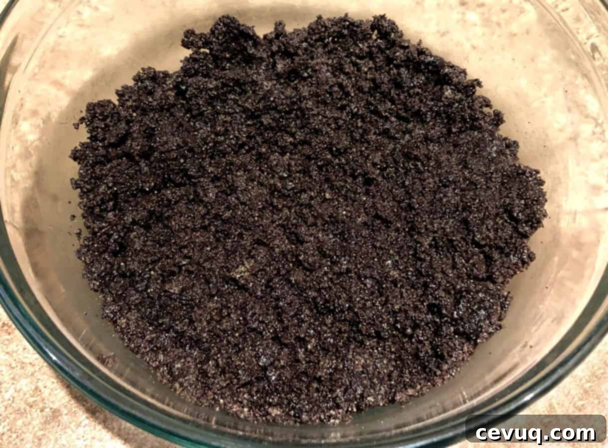 Παγωτοτάρτα Όρεο Μέντα 5 Τριμμένα Oreo και βούτυρο σε ένα μπολ για βάση πίτας.