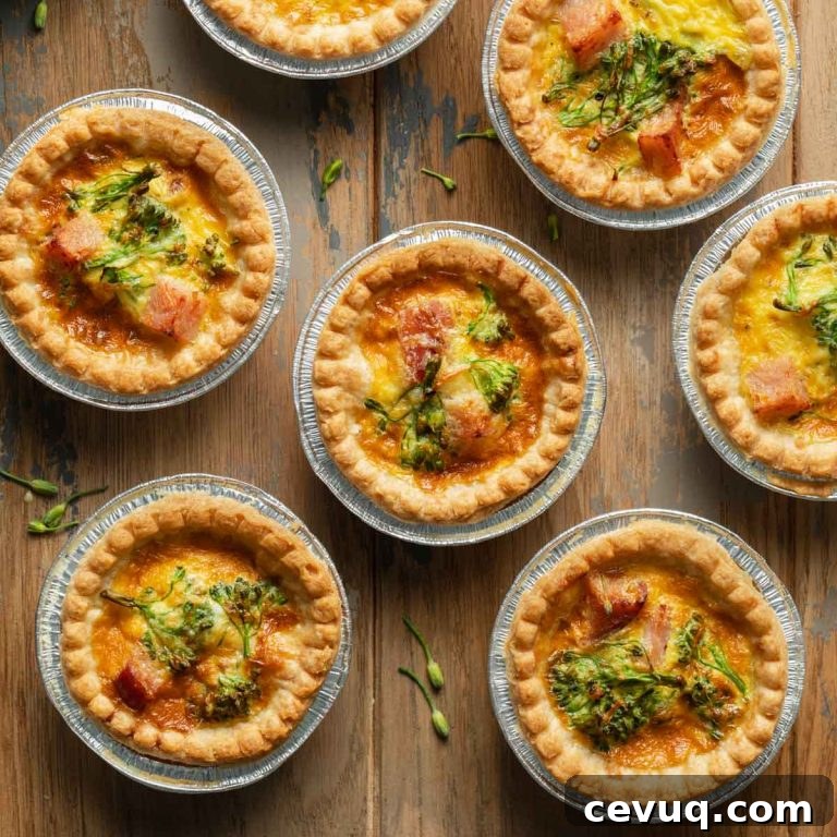 Mini quiche in tart shells arranged on a wooden surface.