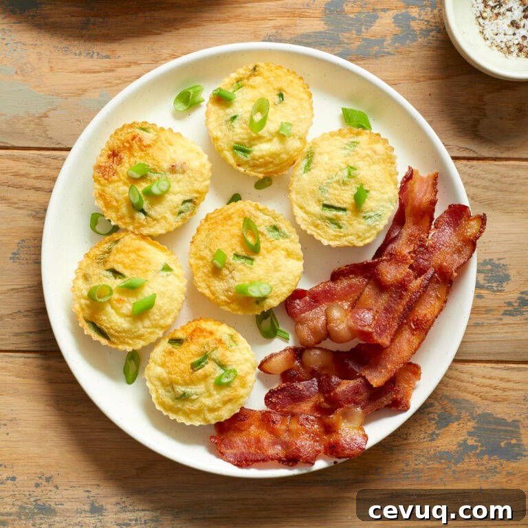 Air fryer egg bites on a white plate with slices of bacon.