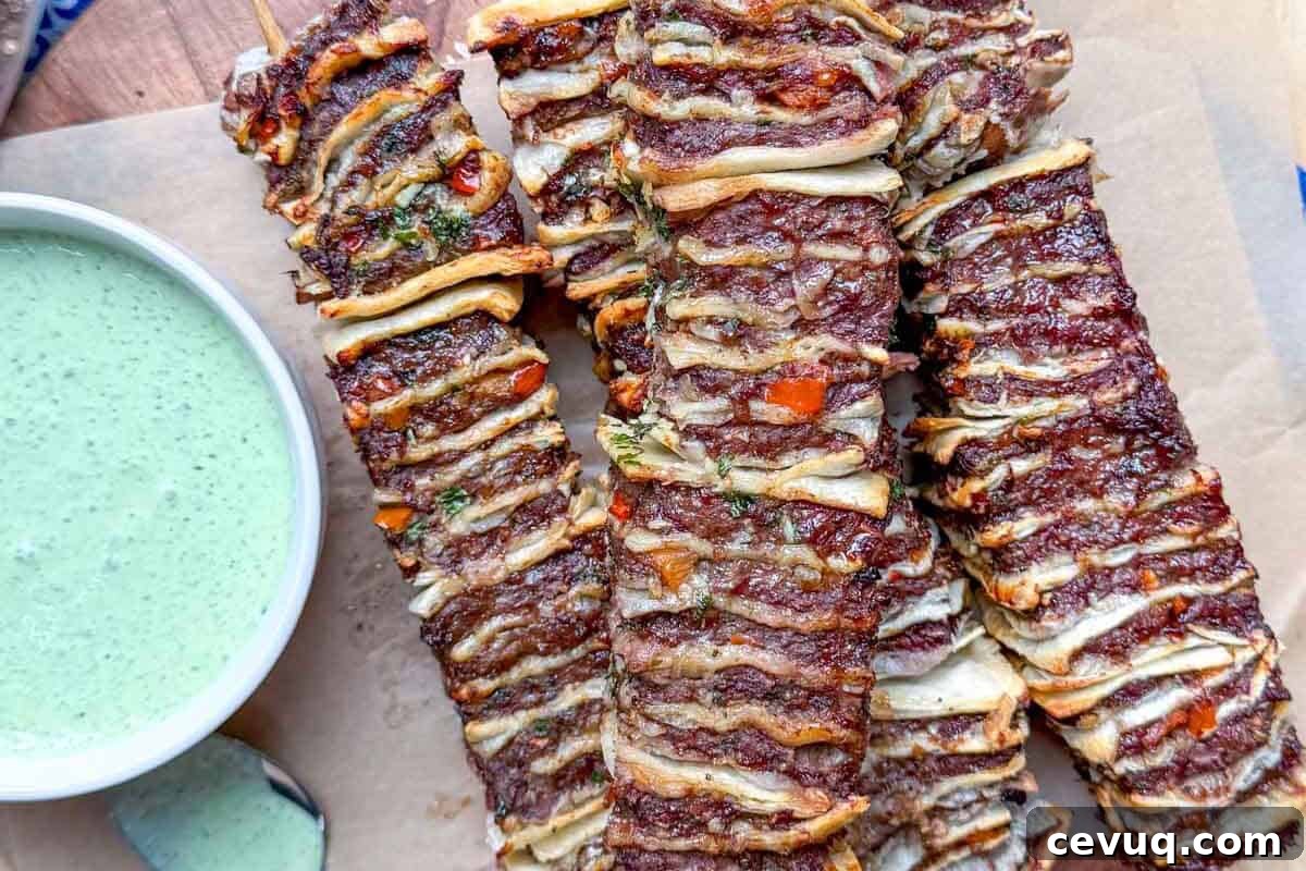 tortilla kebabs on a cutting board with yogurt dip on the side.