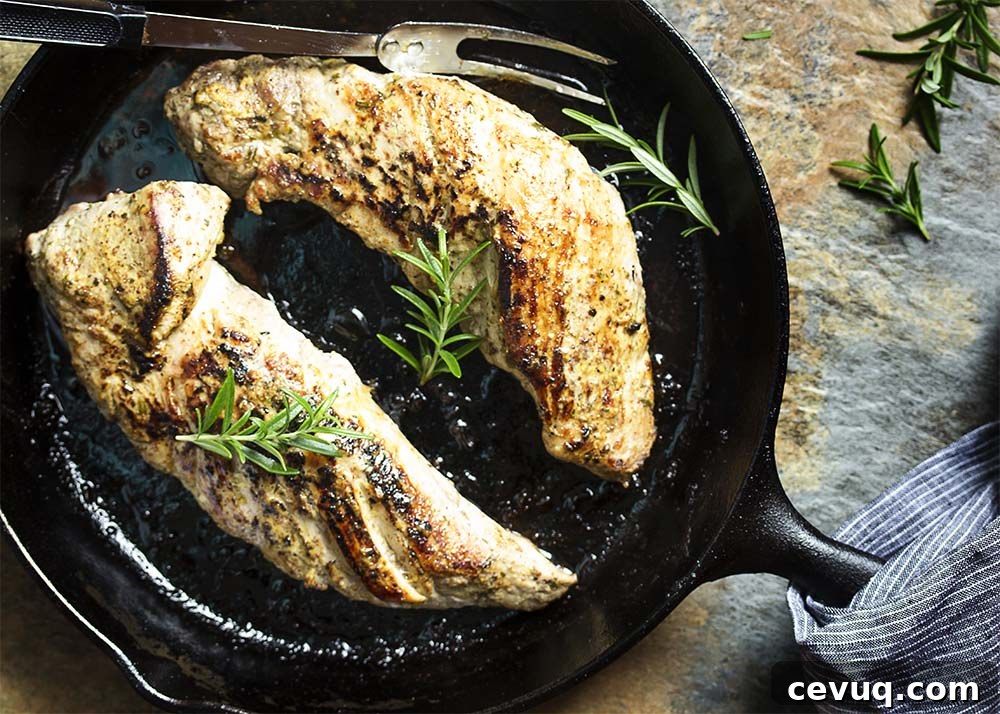 Top view of two pork tenderloins in a skillet browned from being seared and roasted.