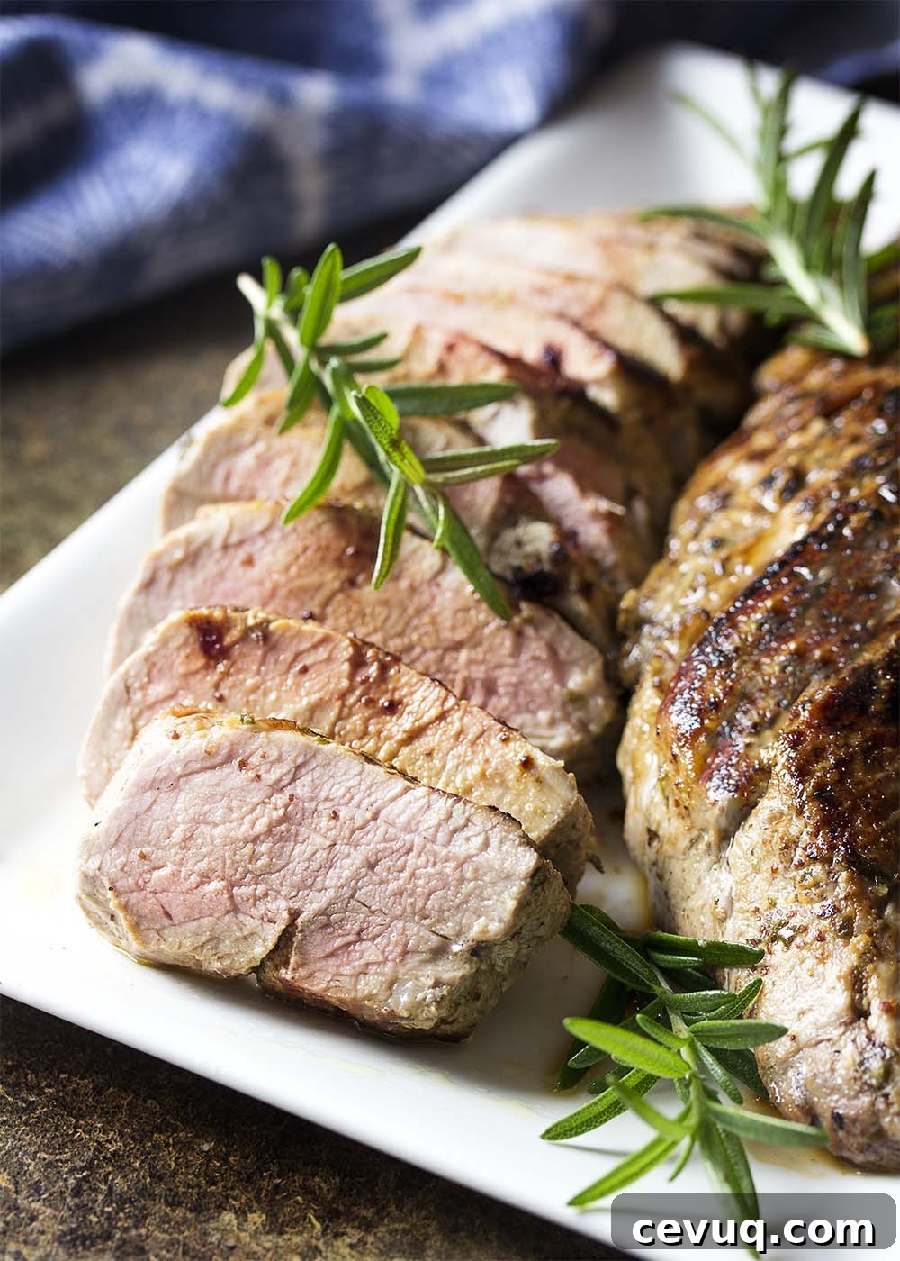 Sliced roast pork on a platter showing the juicy, pink interior of the meat.