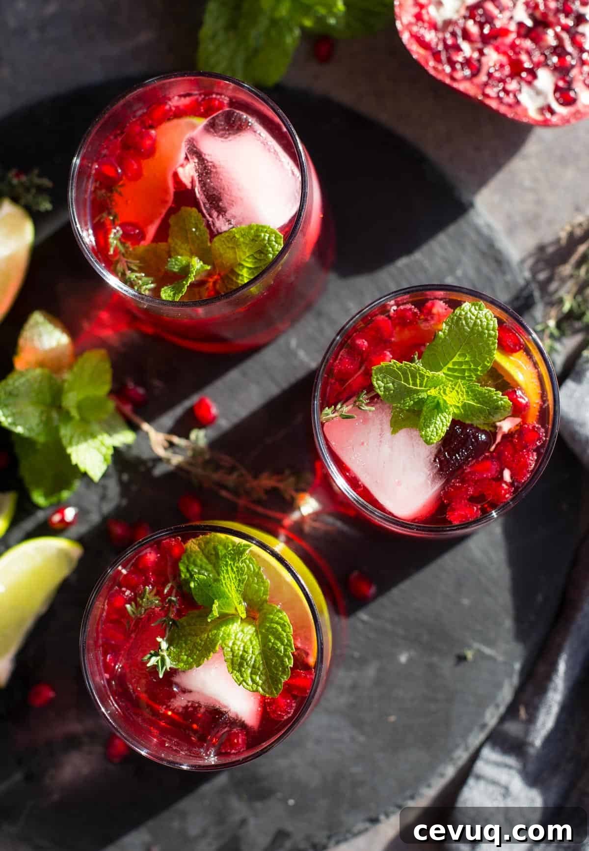 Three festive holiday cocktails on a black slate serving platter