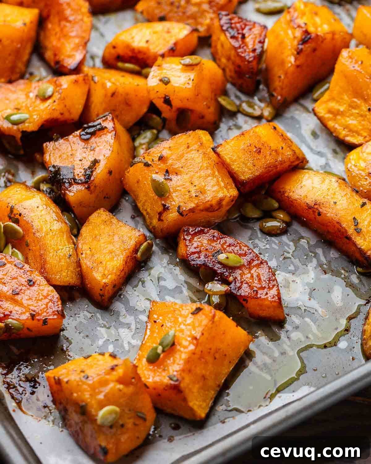 Cinnamon roasted butternut squash on grey baking sheet.