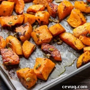 Featured image of roasted butternut squash in grey parchment paper lined baking sheet.