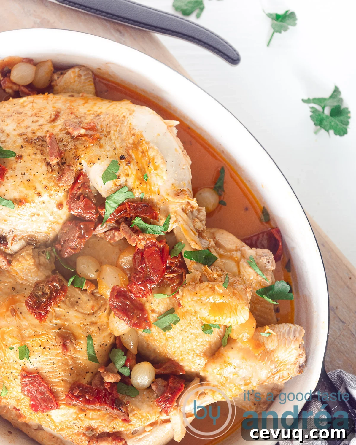 A casserole with coq au vin blanc, bacon and tomatoes