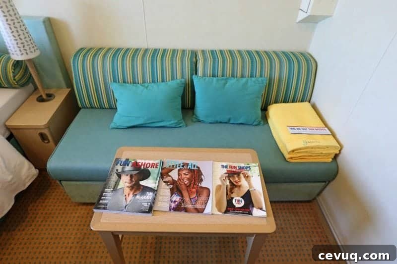 Carnival Sunshine Cloud 9 Spa Stateroom Tour & Review (Video) 7 couch with yellow towels, carnival magazines, and a nightstand