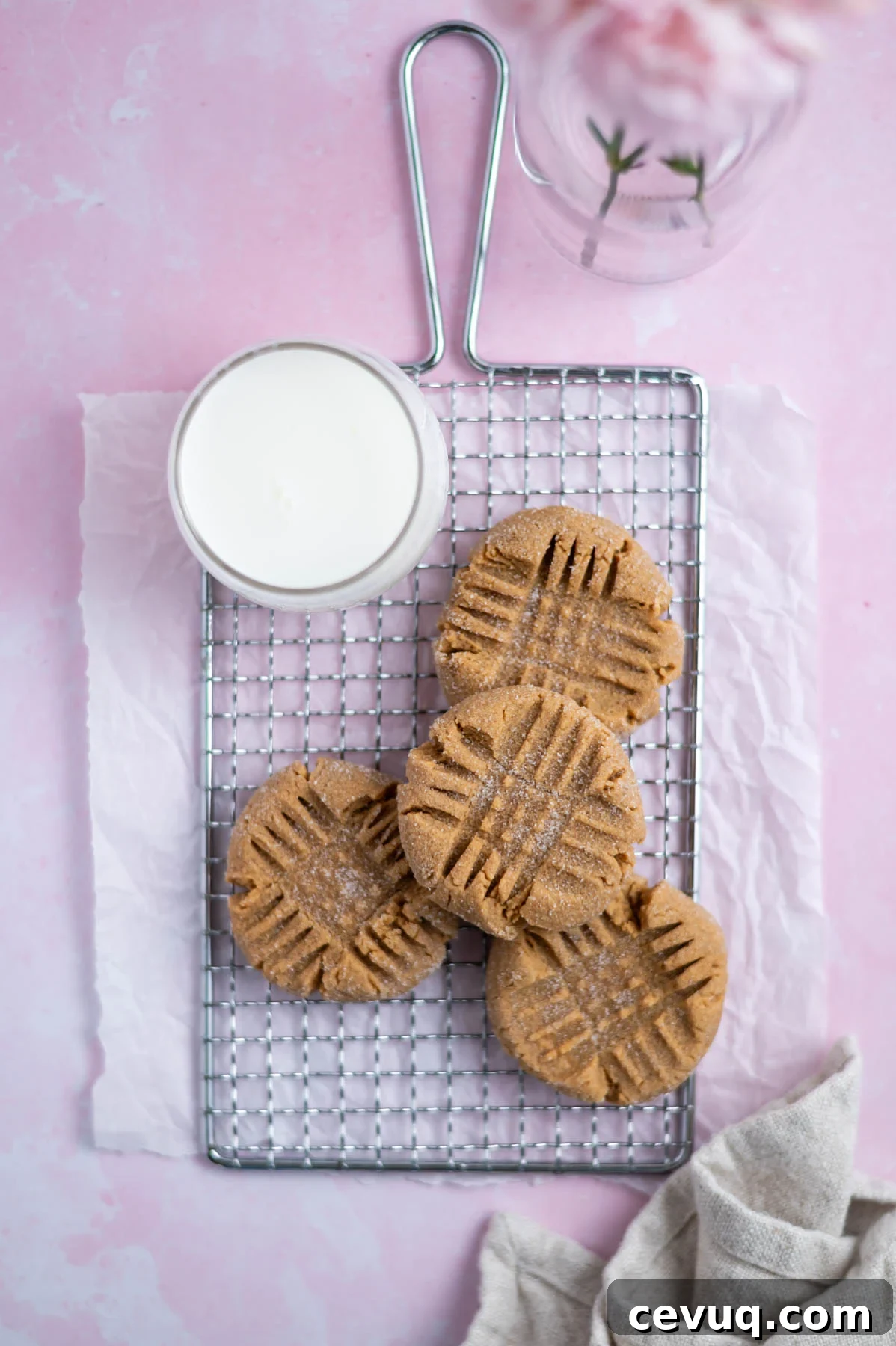 small batch peanut butter cookies on a cooling rack with a glass of milk and a napkin